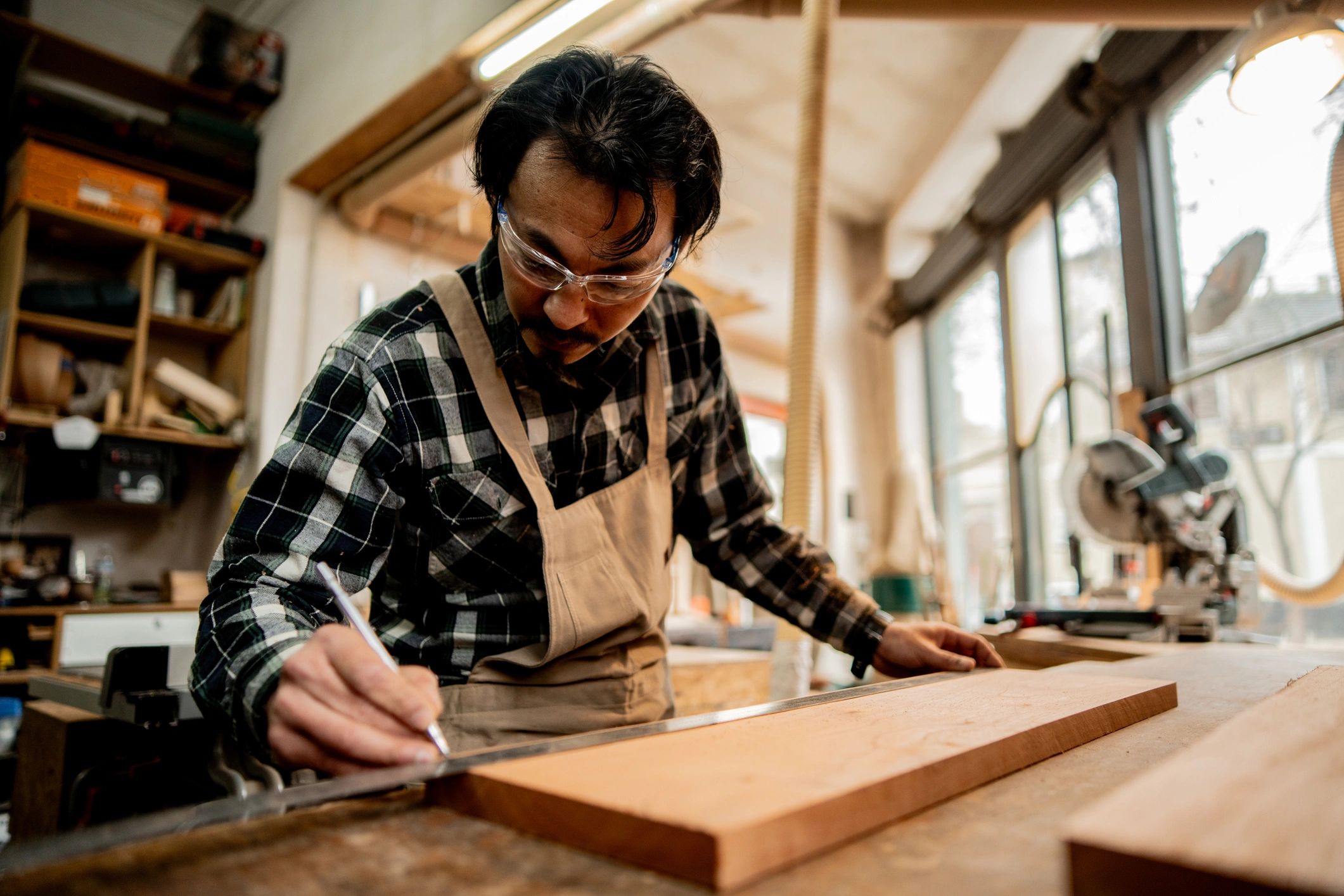 Carpenter measuring a board in a workshop